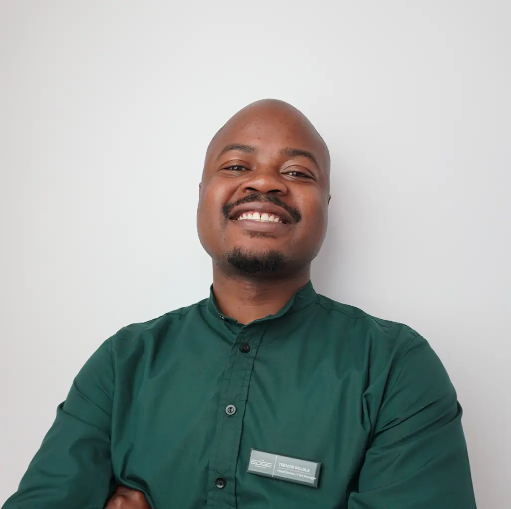 Smiling man in a green shirt stands confidently against a white background, representing our team on the About us page.